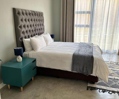 En-suite bedroom with upholstered headboard and full-height windows